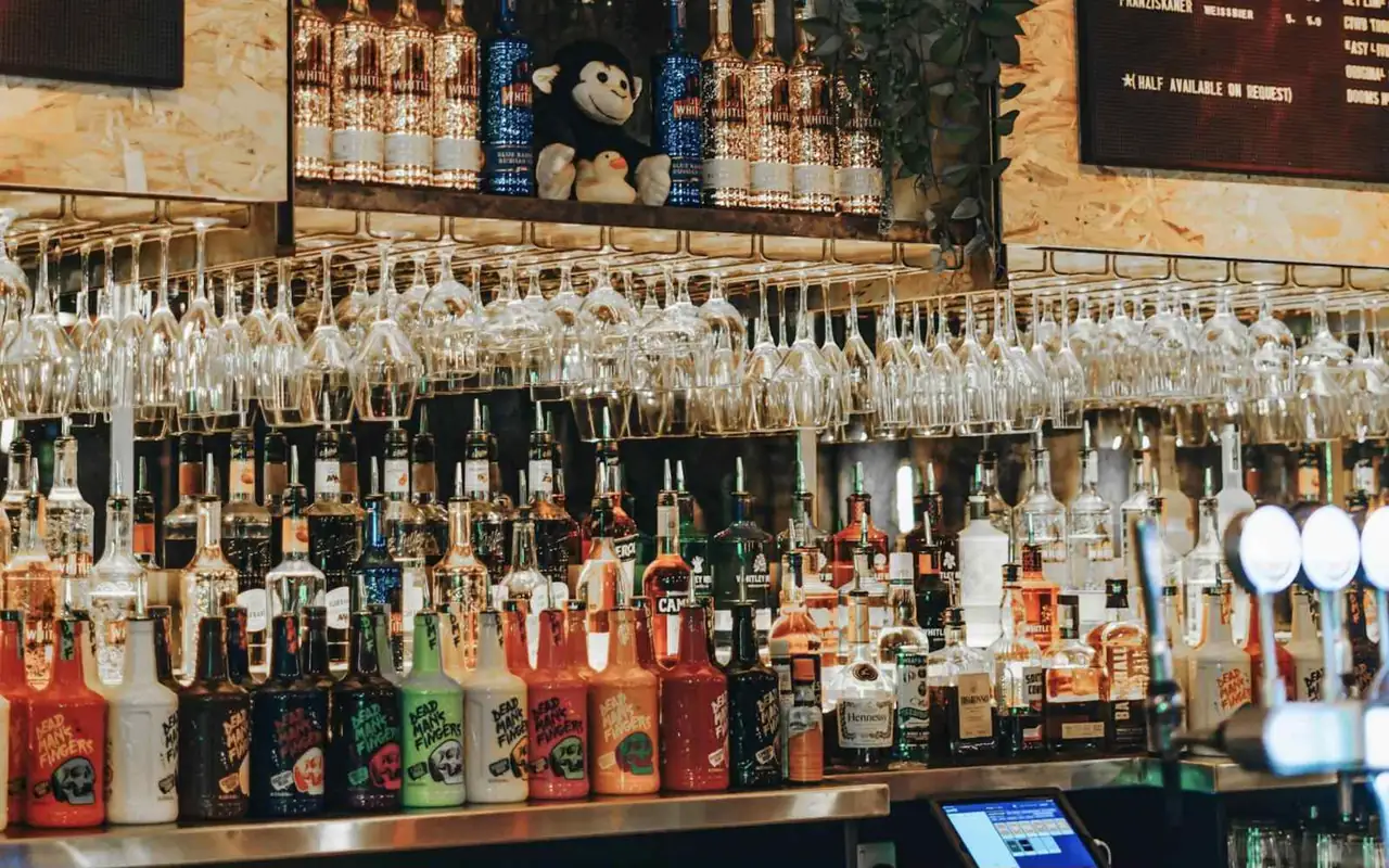 Bancone di un cocktail bar con bottiglie e bicchieri